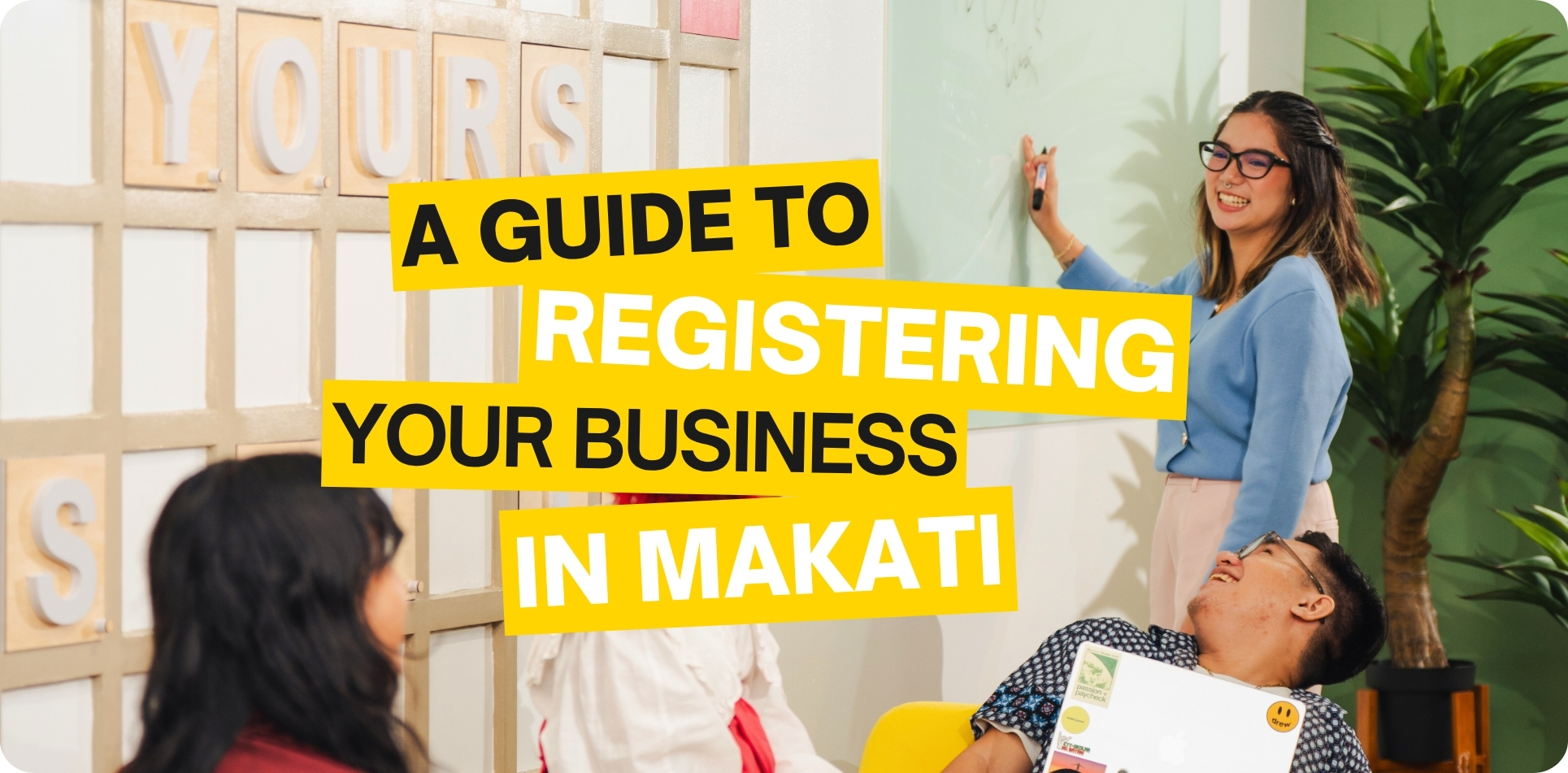 A group of young professionals collaborating inside a modern coworking space with bright decor and indoor plants. A woman in glasses writes on a whiteboard while others listen and smile, creating a casual business meeting vibe. Bold yellow text overlays read ‘A Guide to Registering Your Business in Makati.’ Ideal visual for promoting office for rent in Makati and resources on business registration in Makati.
